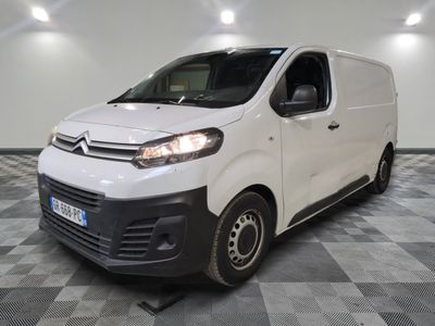 la camionnette blanche est garée dans une grande pièce au sol en damier