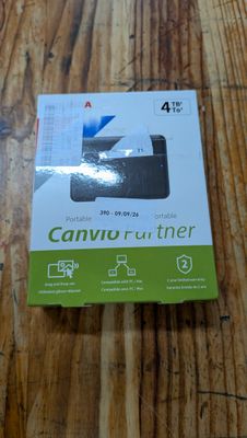 une photo d'un carton contenant une imprimante, posé sur une table en bois