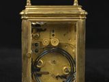 an antique brass carriage clock on a black background