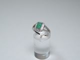 a close up of a ring with a green stone in it