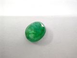 a close up of a green emerald stone on a white surface