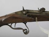 an old rifle with a wooden barrel and a metal handle