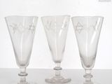 three wine glasses sitting on a table next to each other