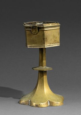 an antique brass candle holder with a box on top of it