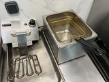 une friteuse posée sur un plan de travail à côté d'un évier