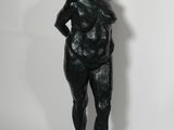 statue d'une femme debout sur un rocher, les mains sur les hanches