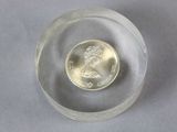 a small glass bowl with a coin inside of it