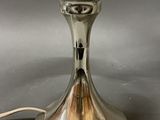 a silver table lamp that is on a table