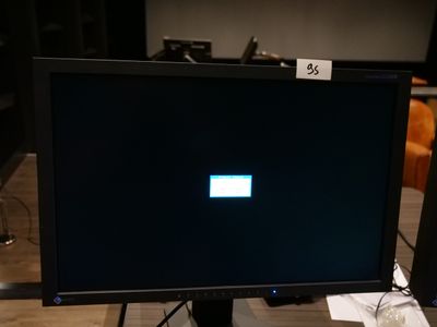 un écran d'ordinateur posé sur un bureau en bois