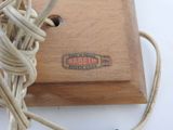 a close up of a wooden box with a rope around it