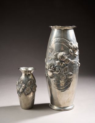 deux vases en argent posés l'un à côté de l'autre sur une table