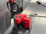 a small red machine that is sitting on the ground