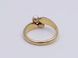 an image of a gold ring with two pearls on it