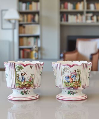 deux vases posés sur une table devant une bibliothèque