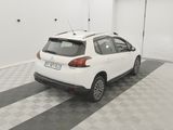 the back of a white car parked in a garage with a checkered floor