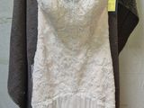 wedding dress hanging on a hanger in front of a brick wall