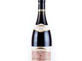 une bouteille de vin posée sur une table blanche
