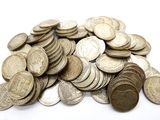 a pile of silver coins on a white surface
