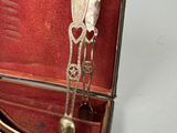 several spoons and forks in a case with a spoon and spoon rest in it
