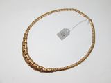 gros plan sur un collier en or portant une étiquette