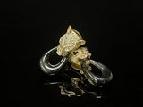 un gros plan d'une bague en or et en argent sur une surface noire