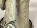 a silver vase with a handle on a white table