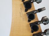 an image of a close up of a guitar neck with a number of knobs on it