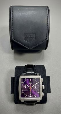 montre et boîtier violets et noirs sur un fond blanc