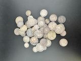 a pile of silver coins sitting on a black surface