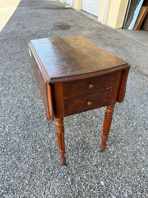 an old wooden table with a drawer on top of it