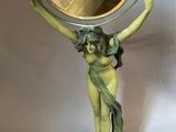 a statue of a woman holding a mirror in her hand