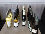 Des bouteilles de vin sont alignées sur une table devant un tableau noir.