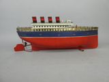an old model of a red, white and blue boat on a white surface