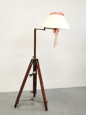 une lampe sur trépied en bois, surmontée d'un abat-jour blanc