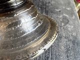 a silver plate on a table with a vase in the background