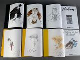 six books with drawings of people on them sitting on a table