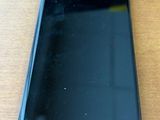 l'arrière d'un téléphone portable noir posé sur une table en bois