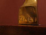 a gold vase sitting on top of a wooden table