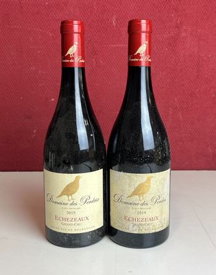 deux bouteilles de vin posées sur un comptoir à côté d'autres bouteilles de vin