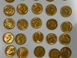 a close up of a pile of gold coins on a white surface
