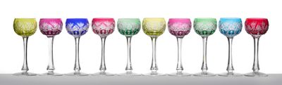 six verres à vin colorés alignés en rang sur une surface blanche