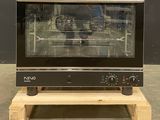 a black oven sitting on a wooden stand in a room