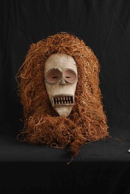 un crâne avec une longue mèche de cheveux roux sur fond noir