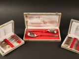 trois cuillères en argent et une cuillère en argent dans une boîte posée sur une table