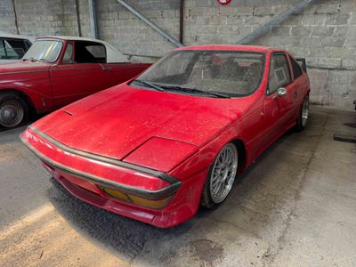 a red car parked in a garage next to another red car