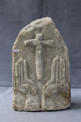 an image of a stone sculpture of a person holding a cross