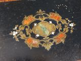a black box with a gold and red emblem on it