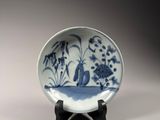 a blue and white plate sitting on a wooden stand