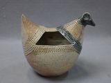 a small bird shaped bowl with a lid on a table