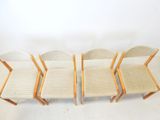 four chairs are lined up in a row on a white surface